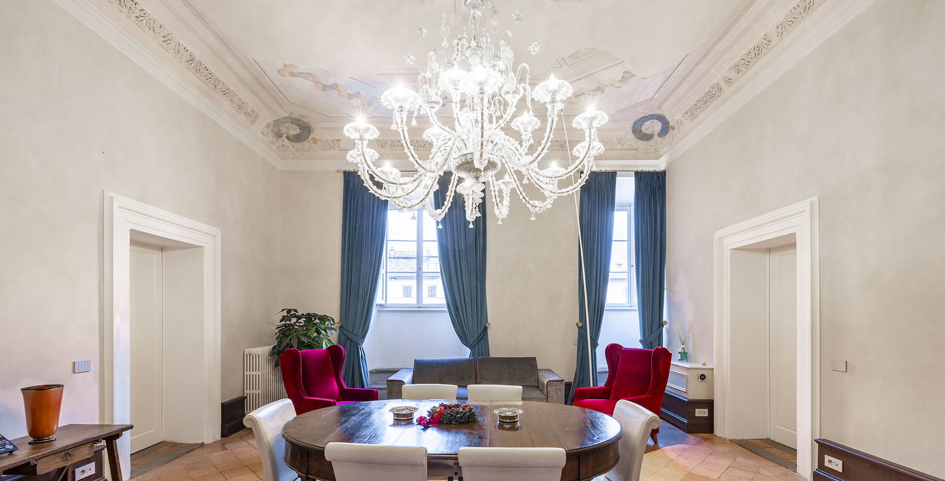 Sala principale della sede Immobiliare Romolini a Sansepolcro, illuminata da lampadari in vetro di Murano realizzati su misura da Multiforme.